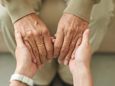 Close-up image of granddaughter holding hands of senior man